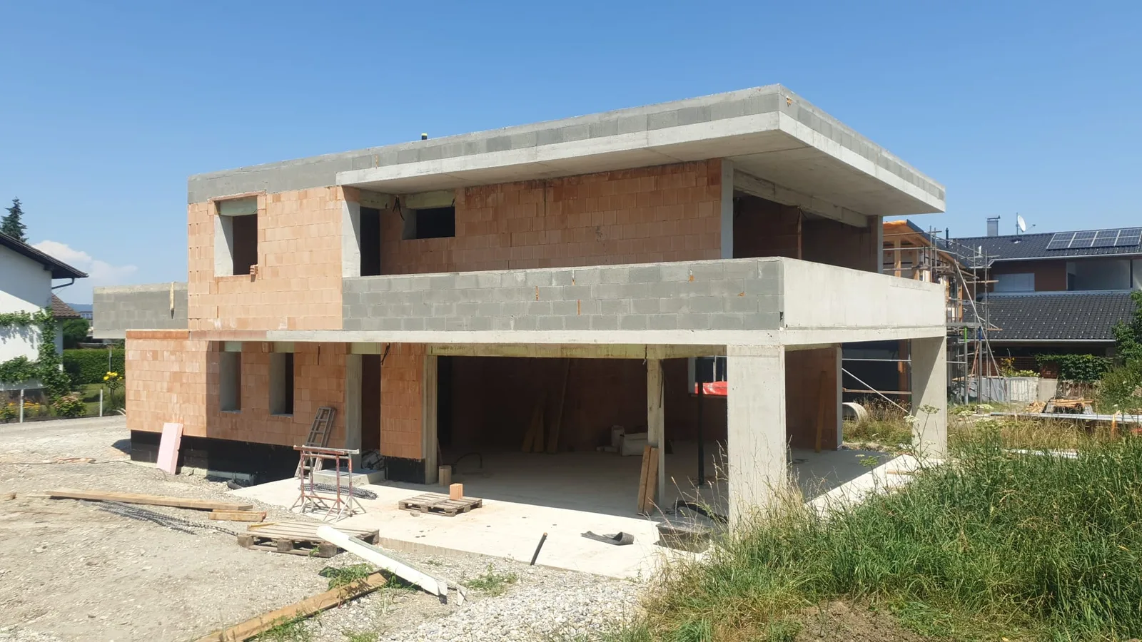 Rohbau eines Einfamilienhauses mit weit auskragender Betondecke über der Terrasse